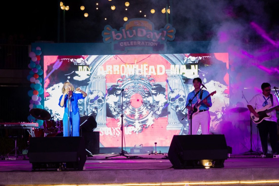Band tampil live di panggung malam dengan LED dan logo It's bluDay Celebration