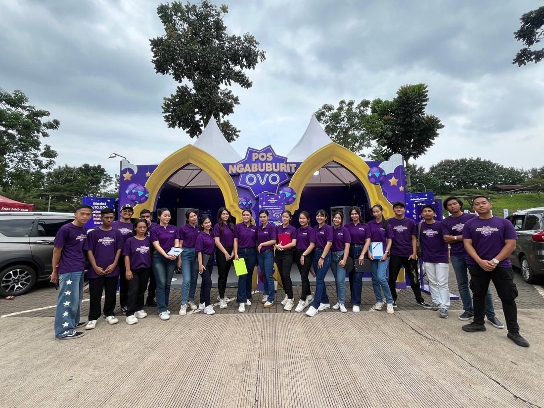 Barisan kru berseragam ungu OVO di depan instalasi Pos Ngabuburit